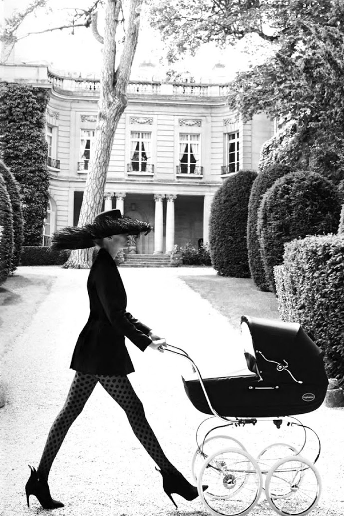 Bella in black, pushing a pram outside a Paris mansion — public, photographed